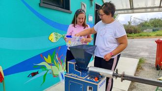 Dos usuarias del centro Misela, manejando una de las m�quinas con las que reciclan pl�stico.