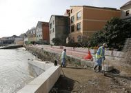 Unos peones construyen una rampa en el paseo mar�timo de Moa�a ante el edificio Salitre. 