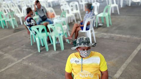 Hombres y mujeres esperan en Bangkok para solicitar ayudas del gobierno
