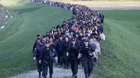 Refugiados sirios escoltados por la polica eslovena en Brezice