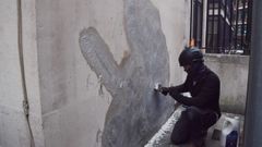 Un trabajador limpia una de las obras de Banksy en Londres