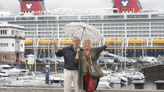 Dos cruceristas del buque Disney Dream, ayer bajo la lluvia en el paseo de la Marina