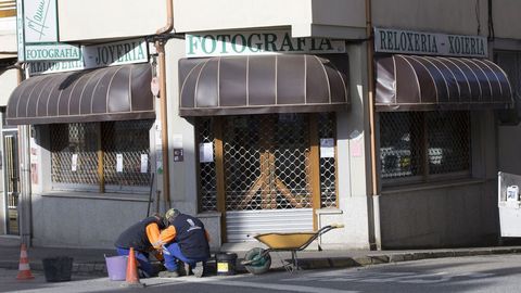 Dos operarios trabajan en una calle vaca de A Fonsagrada