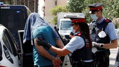 Mossos d'esquadra custodian a uno de los detenidos en la operaci�n contra el terrorismo yihadista que llevan a cabo desde primera hora de la ma�ana en el distrito de Ciutat Vella de Barcelona