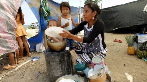 Una mujer ecuatoriana lava los platos en un alojamiento improvisado en Jama tras el terremoto del sbado.