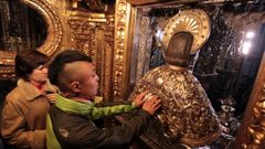 Peregrinos cumpliendo con el rito tradicional del abrazo al Apstol en el camarn que guarda su imagen ms simblica en la Catedral de Santiago