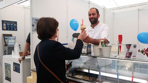 Un heladero le sirve un cucurucho de helado de turrón a una clienta