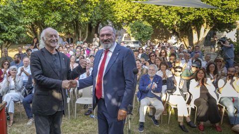 O presidente da Fundaci&oacute;n Rosal&iacute;a de Castro, Anxo Angueira, felicita a Amancio Prada despois de prenderlle na solapa da chaqueta a Rosa de Galicia.