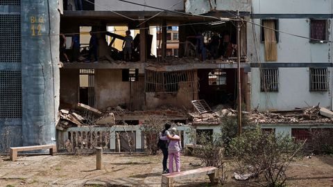 Dos mujeres contemplan un edificio da�ado por los ataque de EE.UU. en Caracas.