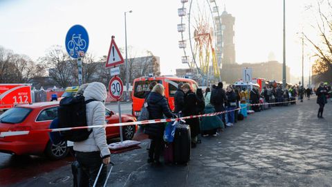 Las personas desalojados del hotel Radisson Collection de Berl�n esperan la llegada de transporte