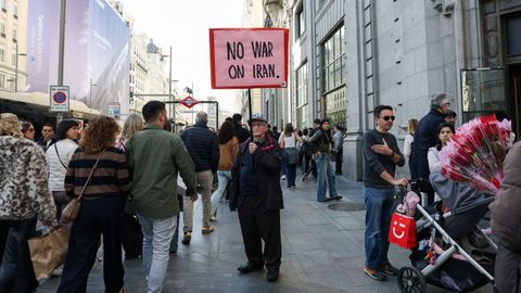 Un hombre sujeta un cartel en el que pide por la paz en Madrid