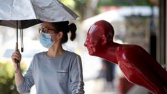 Una mujer, con m�scara en una calle de Bangkok, en Tailandia