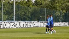Los jugadores del Oviedo pasan por delante de la pancarta