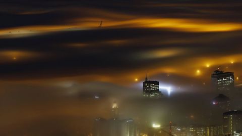 La niebla iluminada por las luces de la ciudad sobre el puero de Ciudad del Cabo.