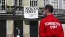 Un bombero, frente a una vivienda con una pancarta de agredecimiento en la localidad de Aveiro