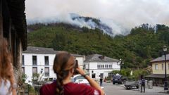 Varias personas observan el incendio que afecta a los alrededores de San Antoln de Ibias