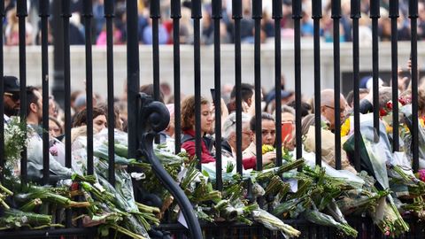 Miles de personas, cargadas con flores y regalos, se acercaron a la verja del palacio de Buckingham.