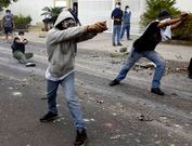 Manifestantes tensionan tirachinas dirigidos contra agentes de polic�a.