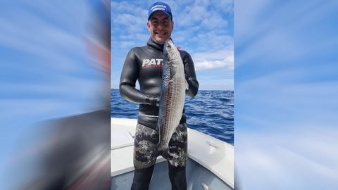 Ezequiel Orosa, con el ejemplar de mújol, a bordo de su planeadora, Royez