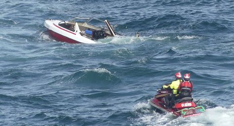 Labores de reflote de la lancha que se hundi en la costa de Seixo Branco, en Oleiros.