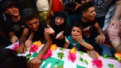 Familiares de uno de los dos l�deres asesinados de Hezbollah, Abu Ali al-Debbi, lloran sobre su ata�d este lunes en Bagdad (Irak) tras morir en el �ltimo bombardeo de drones  contra las Fuerzas de Movilizaci�n Popular Iraqu�es chi�es, respaldadas por Ir�n, en un ataque que tuvo lugar este domingo en la frontera entre Irak y Siria