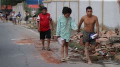 Residentes en Catia La Mar (La Guaira, Venezuela), caminan por las calles rodeados de edificios derruidos.