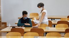 La distancia de seguridad que redujo los aforos de las aulas hizo que la pasada selectividad la relaci�n entre estudiantes y docentes durante las pruebas fuese muy fluida. En la imagen, un alumno de UVigo recibe el examen de una profesora en la ABAU del pasado septiembre