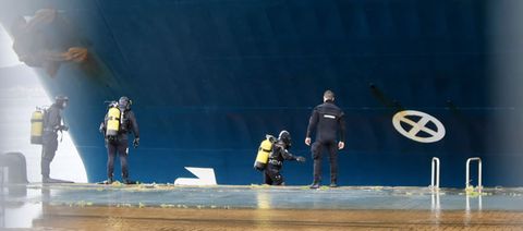 Los buzos inspeccionan el casco del buque que choc con el pesquero