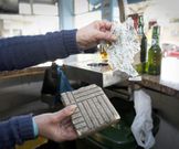 La hostelera, mostrando la baldosa usada para romper el cristal. 