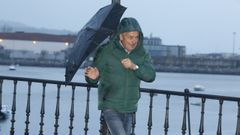 Un viandante se enfrenta a la lluvia en el puente de A Misericordia, en Viveiro