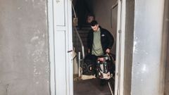 Un hombre saliendo con sus pertenencias de un edificio bombardeado en una zona residencial