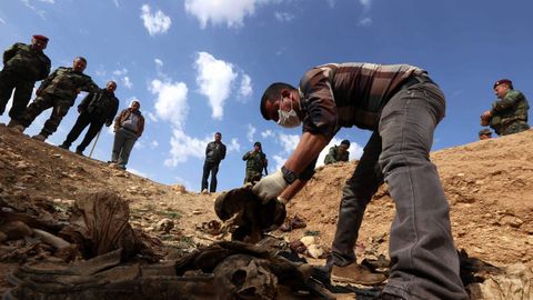 Un hombre de la minora yazid apila hallazgos en una fosa de la localidad de Sinuni