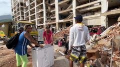 Fredy Silva y Yumely Aguilera con una nevera que acaban de recoger en su apartamento, ubicado en un edificio en ruinas.
