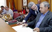 El alcalde, de pie, charla con el portavoz del PSOE antes del debate del presupuesto.