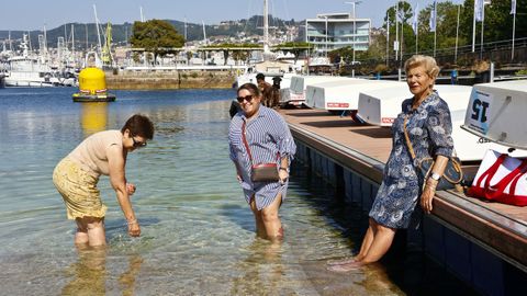 Vecinas de Vigo se refrescan en un pantalán en un día de calor de este verano.