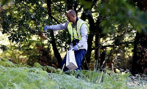 Un guardia civil busca pruebas en la zona donde apareci� el cad�ver de la menor.