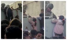 Una familia afgana pasando a una ni�a al otro lado de la valla donde se encuentran los soldados estadounidenses