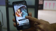 Mahmud muestra una de las im�genes que le llegan de un hospital de Gaza: una�madre abrazada�a su beb�, ambas muertas.