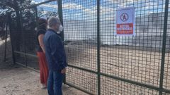 Mara Albert y Luis Menor, con mascarillas, ante el vertedero que sigue ardiendo en A Ra de Valdeorras