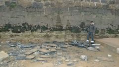 Un chico observa la falta de arena en la playa de San Lorenzo junto a la escalerona