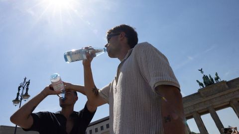 Dos personas bebiendo agua bajo el sol en la Puerta de Brandemburgo (Berl�n).