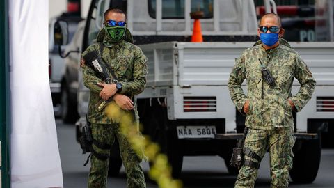 Dos oficiales de polic�a filipinos montan guardia ante un centro de test de covid-19 en el sur de Manila