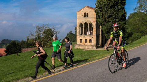 Personas descienden del monte Naranco ante la Iglesia de Santa Mara del Naranco, en un dia con menos paseantes en el segundo da que se permiten los paseos de adultos y el deporte individual al aire libre. EFE/Alberto Morante