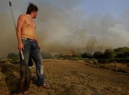 Un hombre que ayuda a combatir un fuego en Bonxe (Outeiro de Rei) observa las llamas a lo lejos.