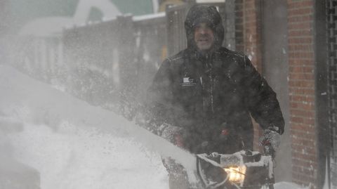 Un hombre despejando las aceras con su m�quina quitanieves.