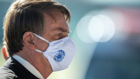 El presidente de Brasil, Jair Bolsonaro, sale ayer viernes con mascarilla del Palacio da Alvorada (residencia presidencial), en Brasilia 