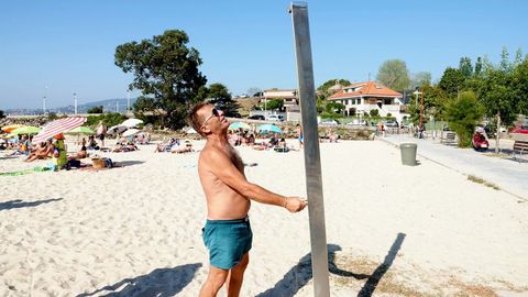 Un usuario, en una playa de Baiona cuyas duchas fueron suprimidas hace tres años por la sequía