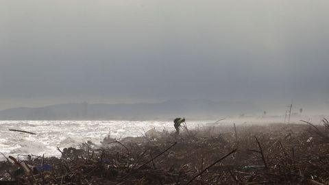 Búsqueda de víctimas en la playa del Saler, cerca de Valencia, donde se amontona basura arrastrada por la dana