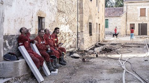 Bomberos descansan luego de intentar extinguir un incendio forestal en Burgos