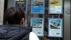 Imagen de archivo de una mujer observando ofertas de viajes de una agencia tradicional